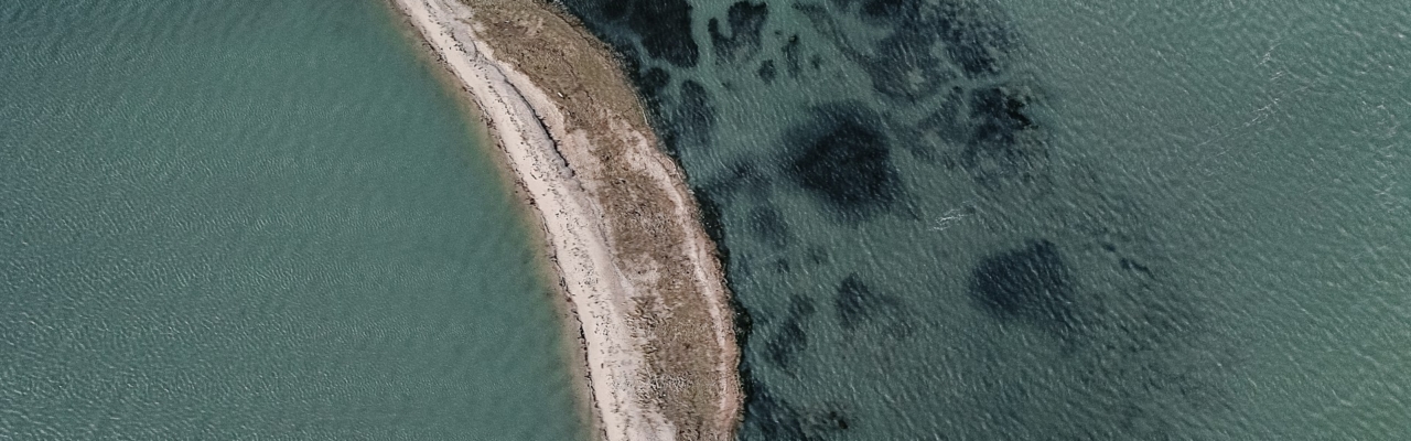 Aerial view of a narrow strip of land surrounded by water